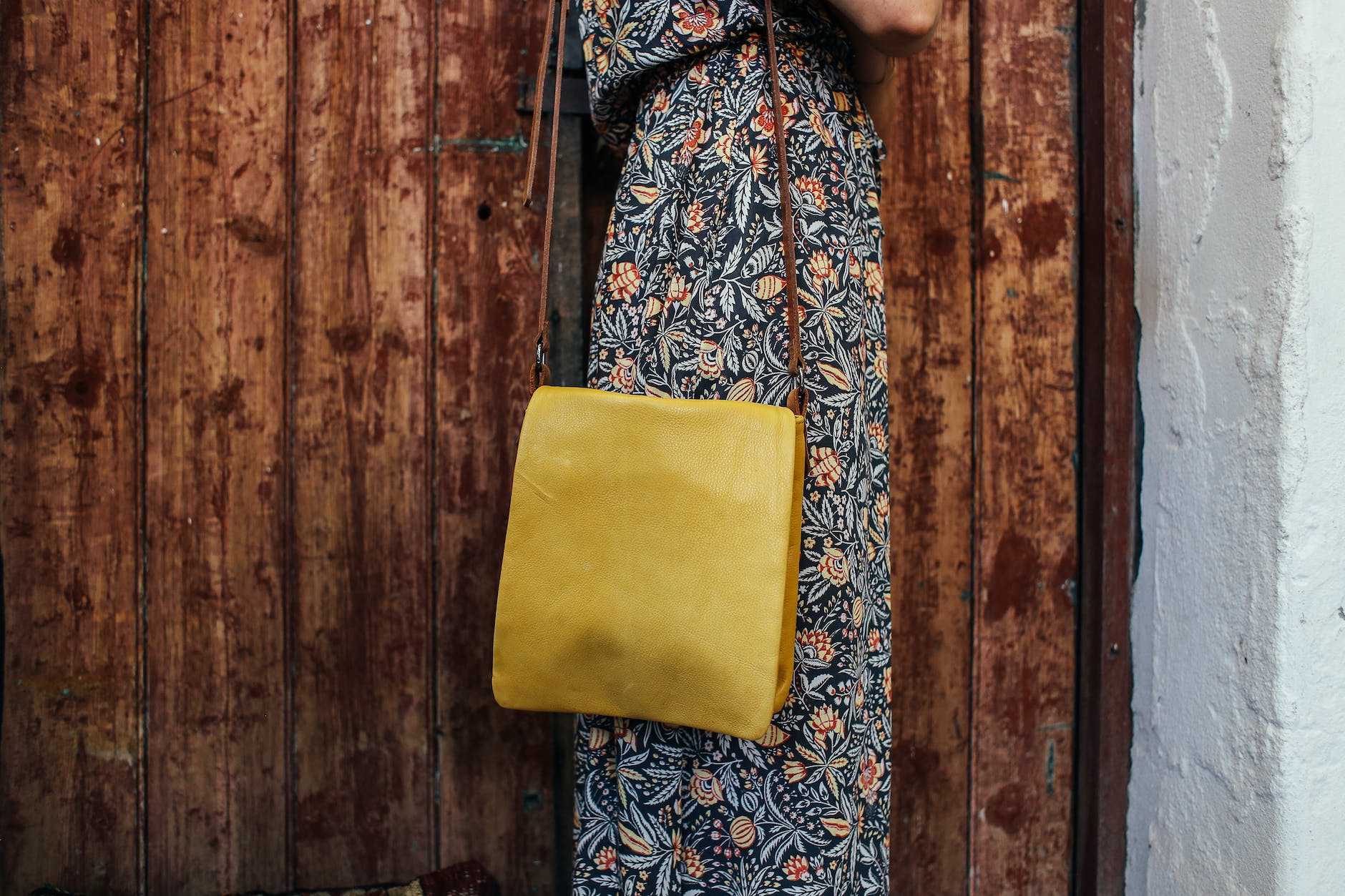 person in floral dress with yellow shoulder bag